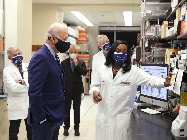 U.S. President Joe Biden and Former U.S. Chief Medical Advisor to the president and three other people wear masks as a researcher shares new COVID vaccine development updates..